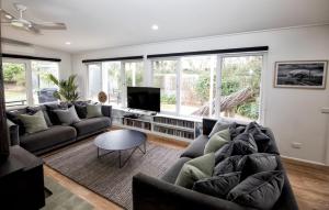a living room with a couch and a tv at LONSDALE ON GLANEUSE in Point Lonsdale