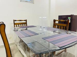 a glass table with four chairs around it at Hillstay Rushikonda in Visakhapatnam