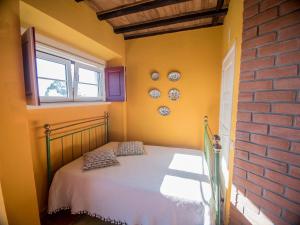 a bedroom with a bed and a brick wall at Casa na Floresta in Figueira da Foz