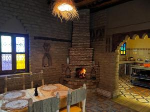 a dining room with a table and a fireplace at Dar Haroun in Rissani