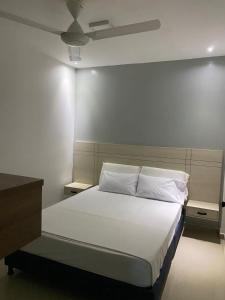 1 dormitorio con cama con sábanas blancas y techo en Hotel River Suite en Leticia