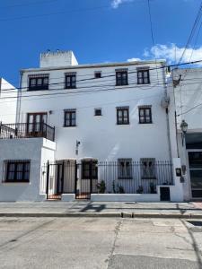 a white building with black windows on a street at Blanc Hotel Boutique in Salta
