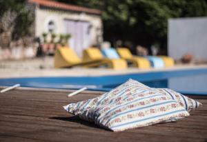 ein Kissen auf einem Tisch neben einem Pool in der Unterkunft Casa na Floresta in Figueira da Foz