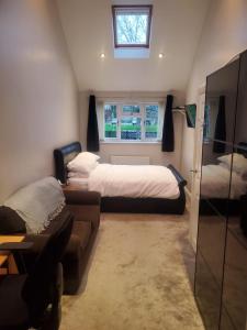 a bedroom with two beds and a couch and a window at Large Kingsize ensuite in Kingswood, Bristol, BS15 in Kingswood