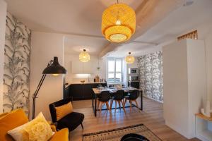 a living room with a table and chairs and a kitchen at Duplex contemporain dans maison du XVIIème siècle in Fougères +26 photos