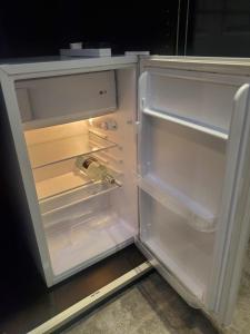 an open refrigerator with its door open at Large Kingsize ensuite in Kingswood, Bristol, BS15 in Kingswood
