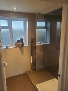 a shower in a bathroom with two windows and a shower at Large Kingsize ensuite in Kingswood, Bristol, BS15 in Kingswood