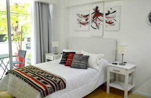 - une chambre avec un lit, deux tables et une fenêtre dans l'établissement Casa ivana 2, à Buenos Aires
