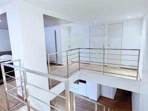 - un escalier dans une chambre blanche dotée d'une balustrade en verre dans l'établissement Loft Saint Thomas - Petite France, à Strasbourg