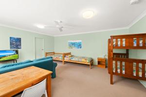 a living room with a couch and a bunk bed at Sandy Shores 18 Corlette Point Road in Corlette