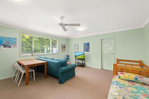 ein Wohnzimmer mit einem blauen Sofa und einem Tisch in der Unterkunft Sandy Shores 18 Corlette Point Road in Corlette