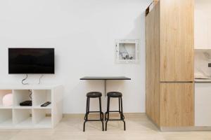 a kitchen with a table and two stools in a room at Nice and cozy Studio Elysée 2 in JVC - Dubai in Dubai