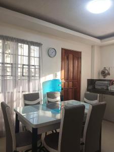 mesa de comedor con sillas y reloj en la pared en Mando Manor -3 Bedroom Private House for Large Group, en Tacloban