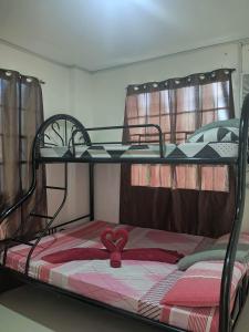 Una litera con una cinta roja encima. en Mando Manor -3 Bedroom Private House for Large Group en Tacloban
