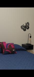 a bedroom with a blue bed with a butterfly on the wall at Caseros in General Alvear
