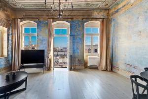 sala de estar con TV y ventana grande en The Ten Syros, en Ermoupoli