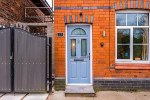 une maison en brique orange avec une porte bleue dans l'établissement Stunning 3-bed home in Nantwich by 53 Degrees Property - Amazing location, Ideal for Groups - Sleeps 6, à Nantwich