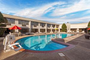 a pool at a hotel with chairs and a building at Best Western Plus Madison-Huntsville Hotel in Madison