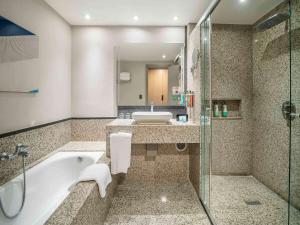 a bathroom with a tub and a sink and a shower at Pullman Sao Paulo Guarulhos Airport in Guarulhos