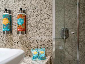 a bathroom with two bottles of soap and a shower at Pullman Sao Paulo Guarulhos Airport in Guarulhos