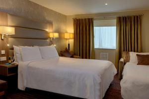Best Western Pontypool Metro Hotel في بونتيبول: غرفة فندقية بسريرين ونافذة