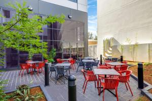 a patio with tables and chairs in front of a building at Travelodge Hotel Sydney Airport in Sydney