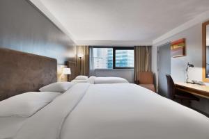 a large white bed in a hotel room with a desk at Park Inn by Radisson Cardiff City Centre in Cardiff