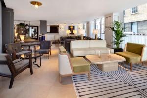 a living room with a couch and chairs at Radisson Blu Edwardian Bond Street Hotel, London in London