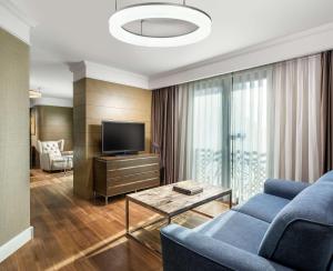 a living room with a blue couch and a tv at Radisson Blu Hotel, Istanbul Sisli in Istanbul