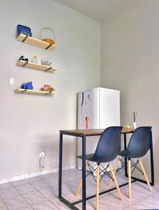 a kitchen with a table and two chairs and a refrigerator at Studio Copacabana Ipanema in Rio de Janeiro