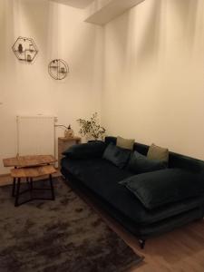 a living room with a black couch and a table at R&N Sea Breeze in Blankenberge
