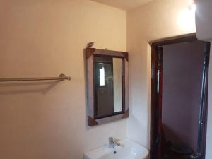 uma casa de banho com um lavatório e um espelho em Auberge des lacs em Imilchil