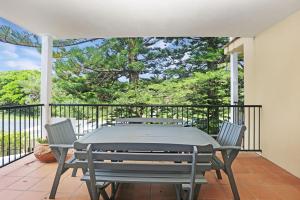a patio with a table and chairs on a balcony at Aquarius Apartment 4 in Hawks Nest