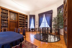 Nové Adalbertinum في هراديك كرالوف: مكتبة فيها طاولة وكراسي