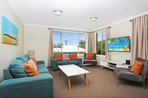 a living room with a couch and chairs and a tv at Aquarius Apartment 4 in Hawks Nest