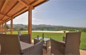 a patio with chairs and a table with a view of a field at Oriental Muti in Chiaramonte Gulfi