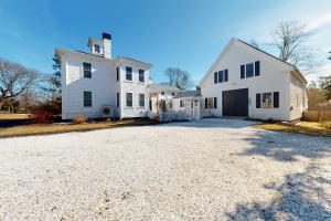 a large white house with a driveway at The Yarmouth House - Carriage House in South Yarmouth