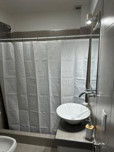 a bathroom with a sink and a shower curtain at Orfila Apart 5 in Mendoza