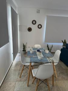 a dining room with a table and white chairs at Orfila Apart 5 in Mendoza