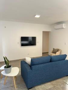 a living room with a blue couch and a tv at Orfila Apart 5 in Mendoza