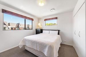 a bedroom with a bed and a large window at Blenheim Palms Motel in Blenheim
