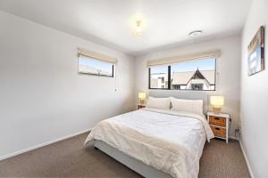 a bedroom with a bed and two windows at Blenheim Palms Motel in Blenheim