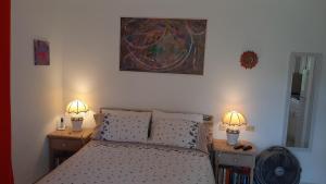 1 dormitorio con 1 cama y 2 lámparas en 2 mesas en Tropical Gecko Studio - Sweet Jewel Apartments, en Christ Church