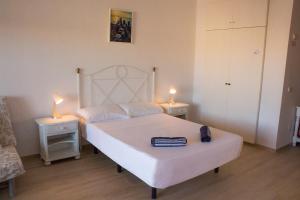 una camera da letto con un letto bianco con due luci sopra di Benal beach suite II, estudio con parque acuático y vistas al mar. a Benalmádena