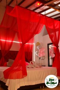 アパルタドにあるHotel San Miguel Apartadóの赤いカーテン付きのベッドが備わる客室です。