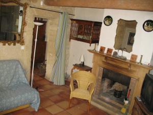 Una sala de estar con chimenea y una silla. en Mas Blauvac avec piscine, Entre Uzes Pont du Gard, en Vers Pont du Gard