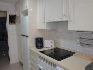 a kitchen with white cabinets and a black counter top at Apartamento Mare Nostrum in Denia