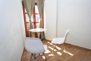 two white chairs and a table in a room with a window at Hotel Grand Guanajuato in Guanajuato
