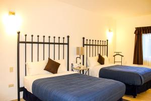 Habitación de hotel con 2 camas con sábanas azules en Real de la Presa en Guanajuato