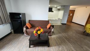 a living room with a couch and a table with flowers at Motel 6-Kewanee, IL in Kewanee